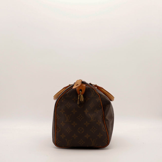 Louis Vuitton Speedy 30 zijaanzicht ritstrekker en lipje hangslot vachette caramel — AMANA Vintage