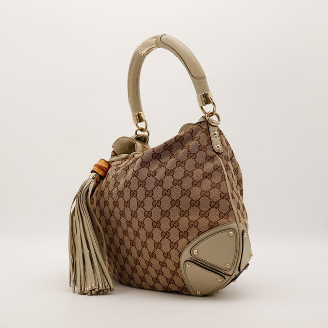 Gucci Indy Hobo vue de trois quarts gauche toile GG Canvas beige detail poignee rigide — AMANA Vintage
