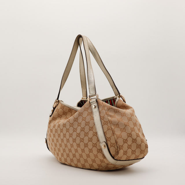 Gucci Hobo GG canvas vue de trois quarts gauche anses cuir doré — AMANA Vintage