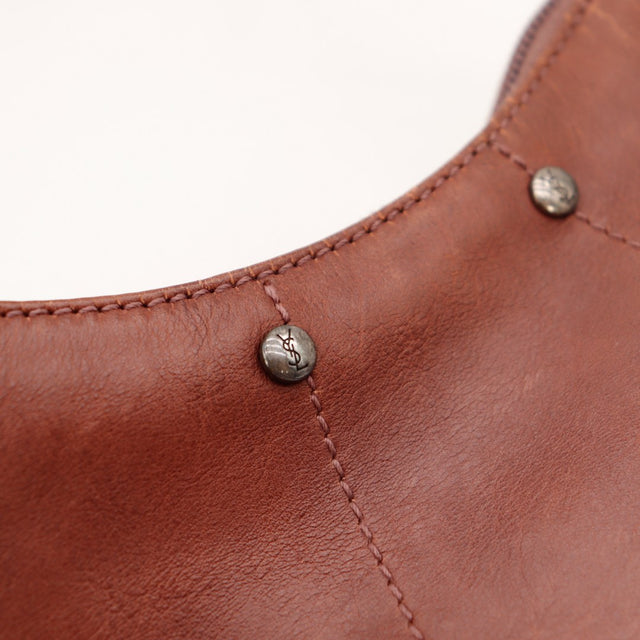 Pormenor rebites YSL sobre pele castanha Yves Saint Laurent Mombasa Hobo — AMANA Vintage