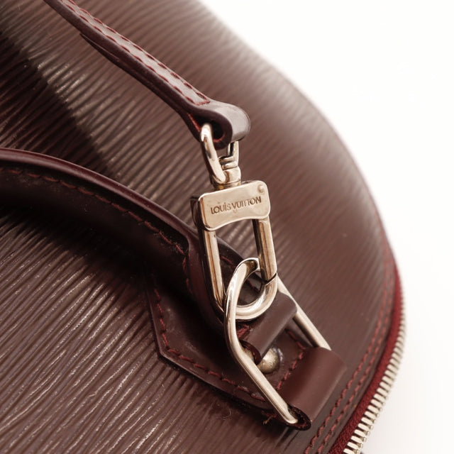 Détail de la fermeture Louis Vuitton Alma PM cuir Épi bordeaux occasion authentique — AMANA Vintage