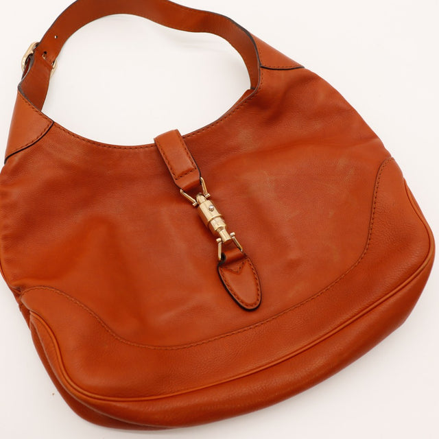 Détail fermoir piston Gucci New Jackie cuir cognac posé occasion authentique — AMANA Vintage