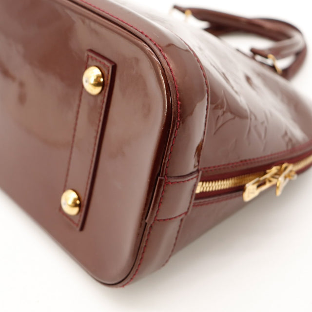 Vue coin inférieur Louis Vuitton Alma PM Vernis Amarante occasion — AMANA Vintage