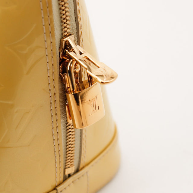Detail cadenas et zip Louis Vuitton Alma MM Vernis kaki avec cle — AMANA Vintage