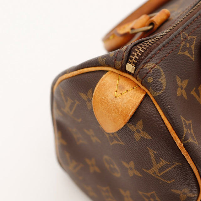 Detail hoeken en tab vachette Louis Vuitton Speedy 25 patine caramel — AMANA Vintage