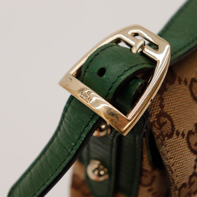 dettaglio della fibbia dorata firmata Gucci su tracolla pelle verde autentico di seconda mano — AMANA Vintage