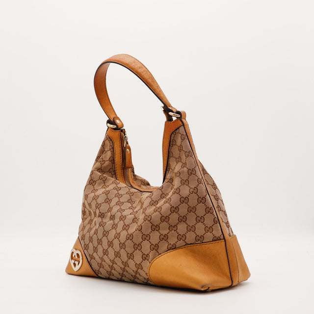 Vue de trois quarts Gucci Hobo Interlocking G toile monogrammée beige et cuir caramel — AMANA Vintage