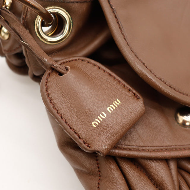 Détail des lanières de serrage Miu Miu Coffer Hobo cuir d'agneau matelassé marron taupe occasion authentique — AMANA Vintage