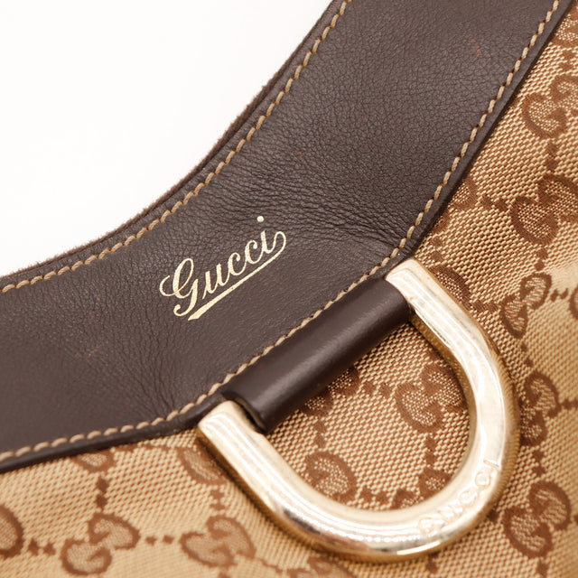 Détail anneau doré et signature Gucci sur cuir chocolat — AMANA Vintage