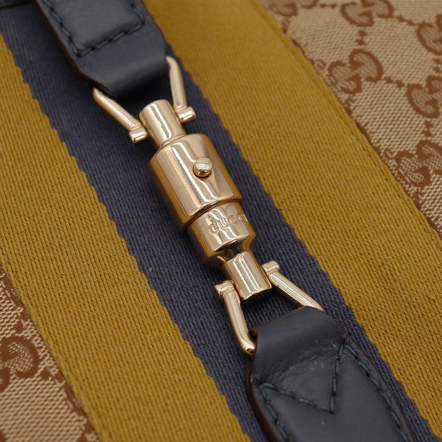 Gros plan fermoir piston doré signature Gucci Jackie occasion authentique — AMANA Vintage