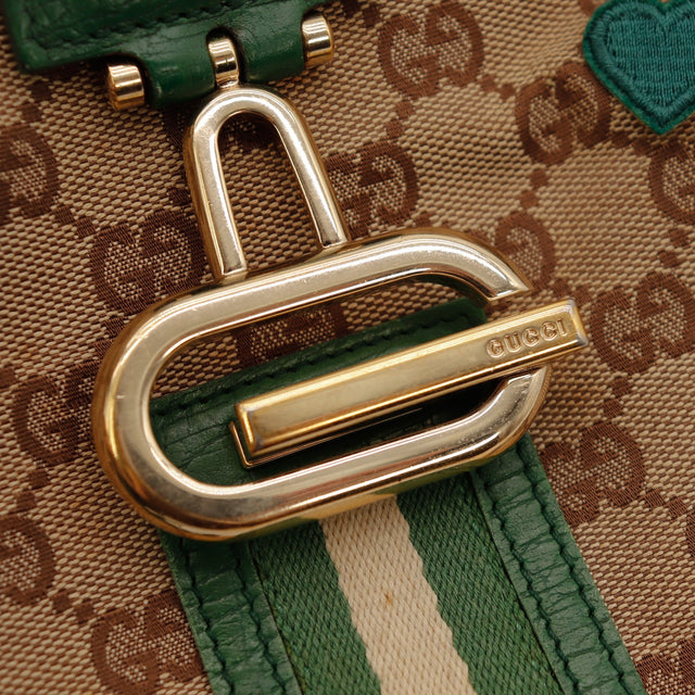 Détail fermoir doré Gucci Hobo Web bande Web verte et blanche — AMANA Vintage