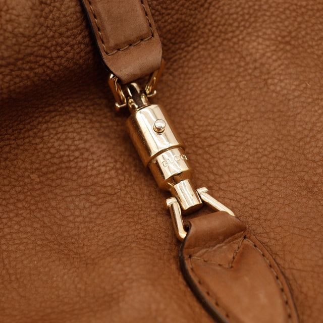 Détail fermoir piston doré Gucci New Jackie cuir marron — AMANA Vintage