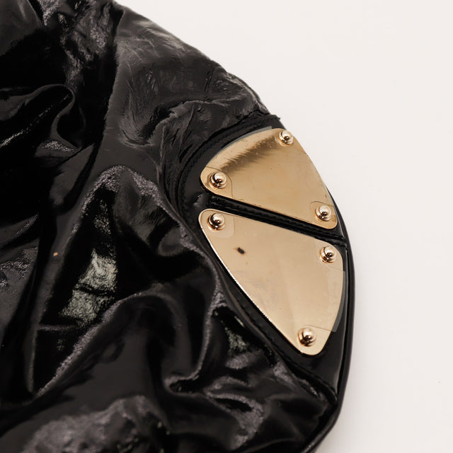 Détail plaque métallique dorée Gucci Indy Hobo cuir verni noir — AMANA Vintage