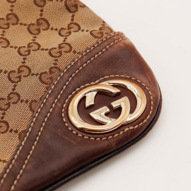 Détail rapproché du logo rond doré Gucci Hobo — AMANA Vintage