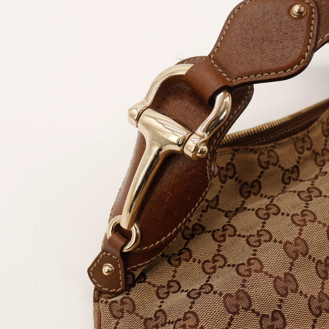Détail pièce métallique dorée et attache cuir du sac Gucci Hobo — AMANA Vintage