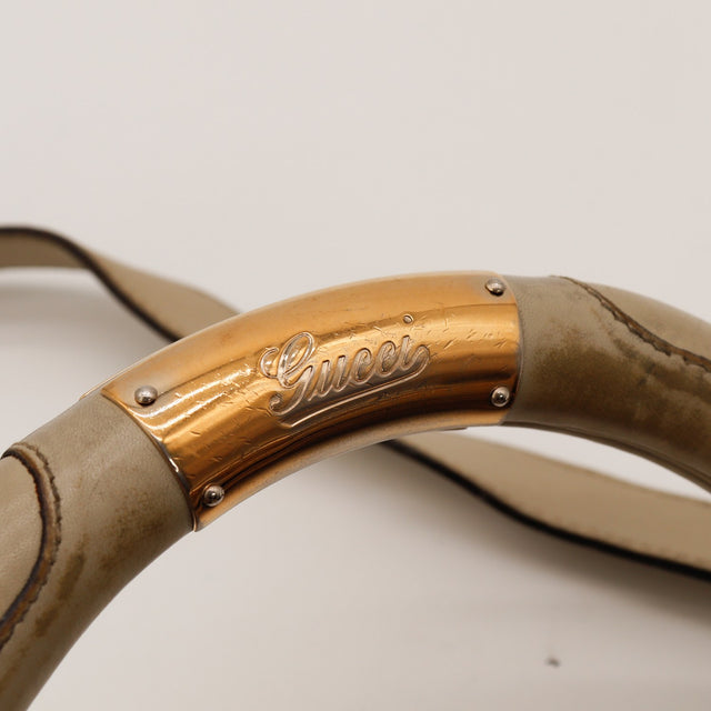 Détail anse cuir et plaque dorée Gucci Indy Hobo — AMANA Vintage
