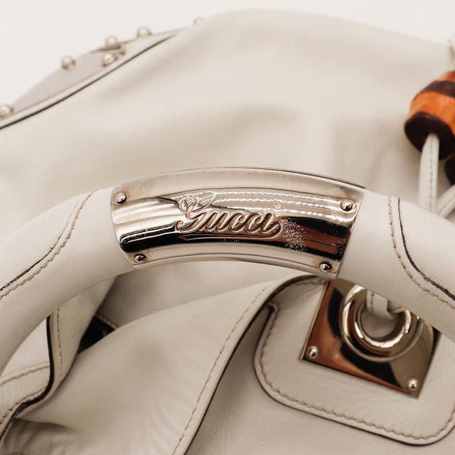 Détail plaque Gucci sur anse rigide sac Indy Hobo cuir ivoire — AMANA Vintage