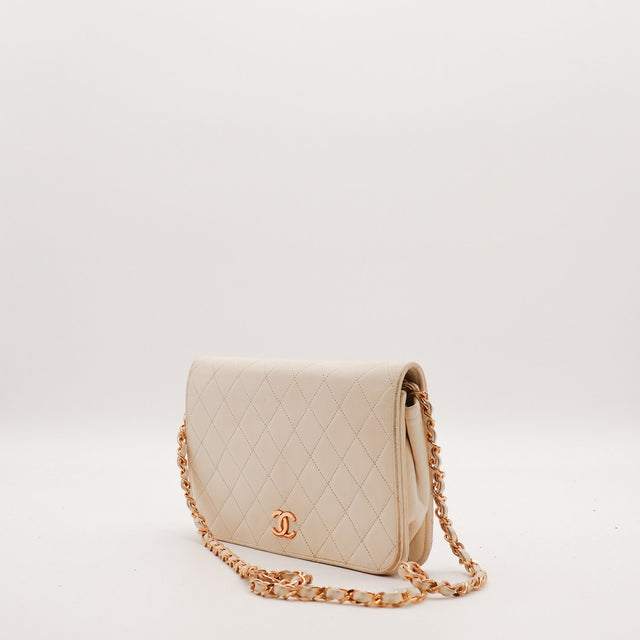 Vue trois-quarts Pochette Chanel matelassée beige chaîne entrelacée cuir occasion — AMANA Vintage