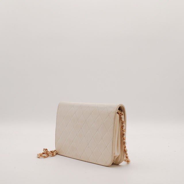 Vue de côté Pochette Chanel matelassée beige profil cuir agneau — AMANA Vintage