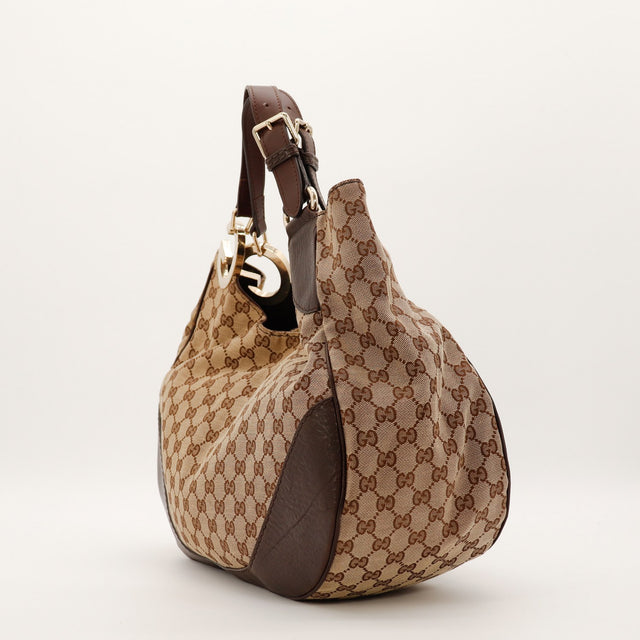 Gucci Hobo Interlocking G toile GG Canvas profil gauche avec breloque doree occasion — AMANA Vintage