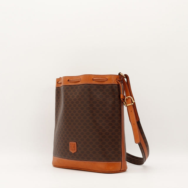 Vue de trois quarts Celine Seau Macadam toile marron garnitures cuir cognac bandoulière réglable — AMANA Vintage