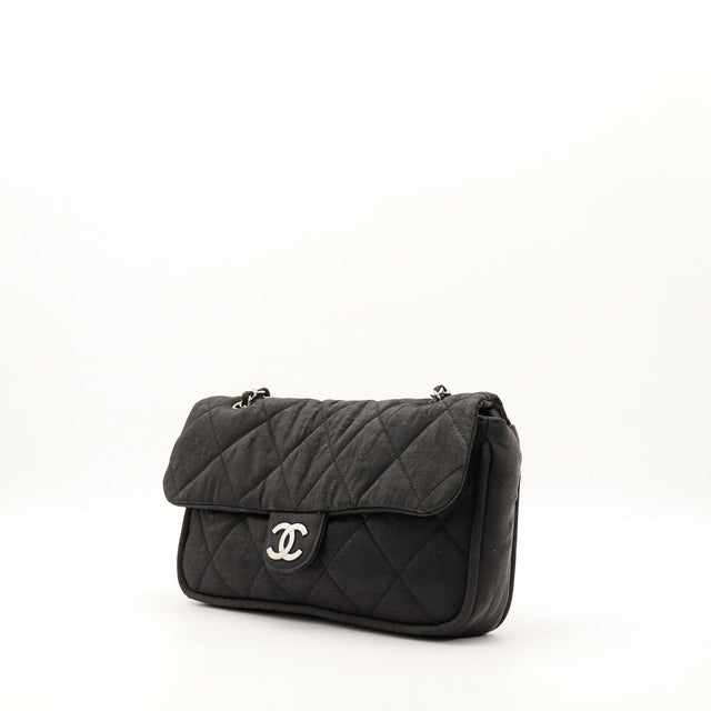 Sac Chanel Timeless tissu matelassé noir vue trois quarts avec chaîne argentée — AMANA Vintage