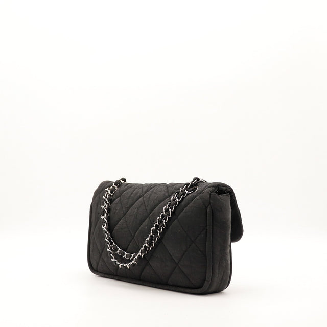 Vue de profil sac Chanel Timeless tissu noir matelassé occasion — AMANA Vintage