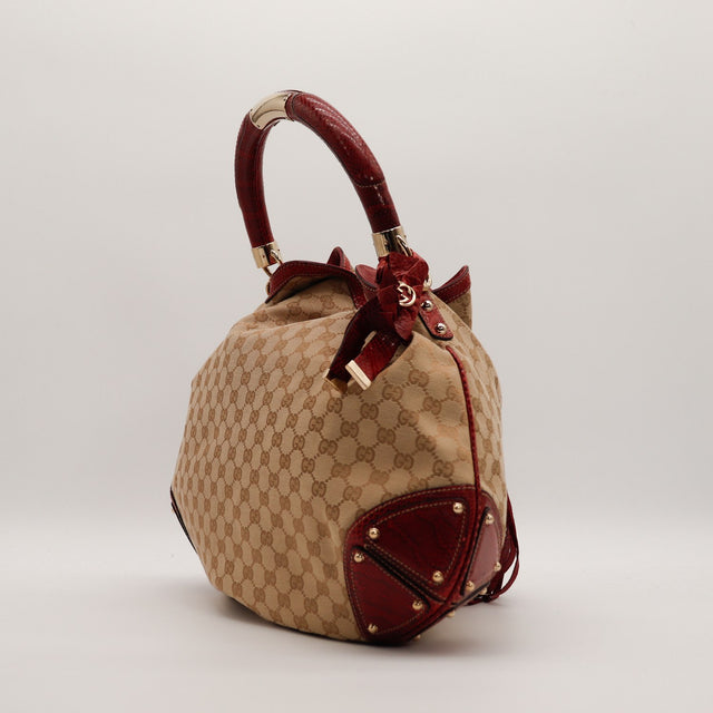 Vue de trois quarts sac Gucci Indy Hobo python rouge pompons bambou — AMANA Vintage