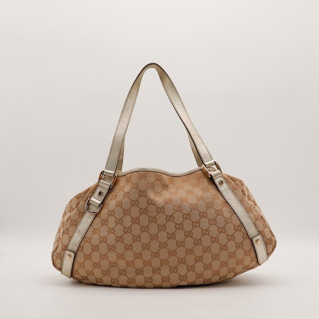 Gucci Hobo GG canvas vue de trois quarts droit détail cuir métallisé — AMANA Vintage