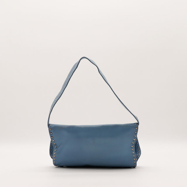 Détail du bouton logo latéral argenté sur sac clouté cuir bleu — AMANA Vintage