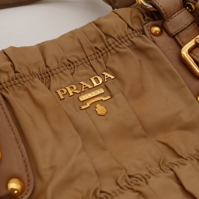 Détail logo Prada Milano doré sur nylon Gaufre camel — AMANA Vintage