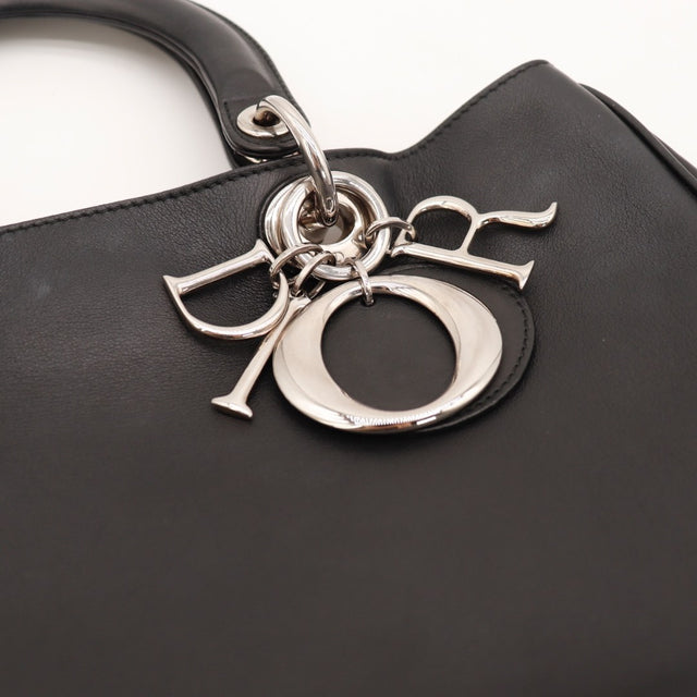 Détail des anses du sac Dior Diorissimo cuir de veau lisse noir — AMANA Vintage