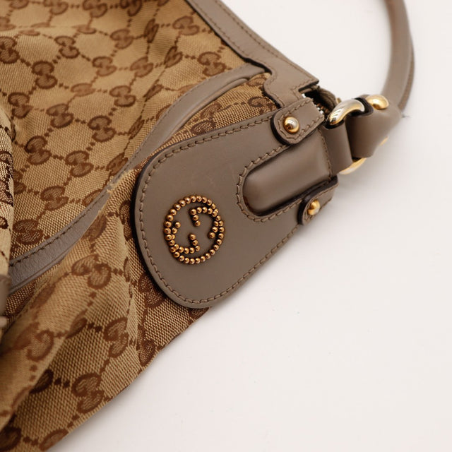 Détail logo Gucci clouté sur tab cuir occasion authentique — AMANA Vintage