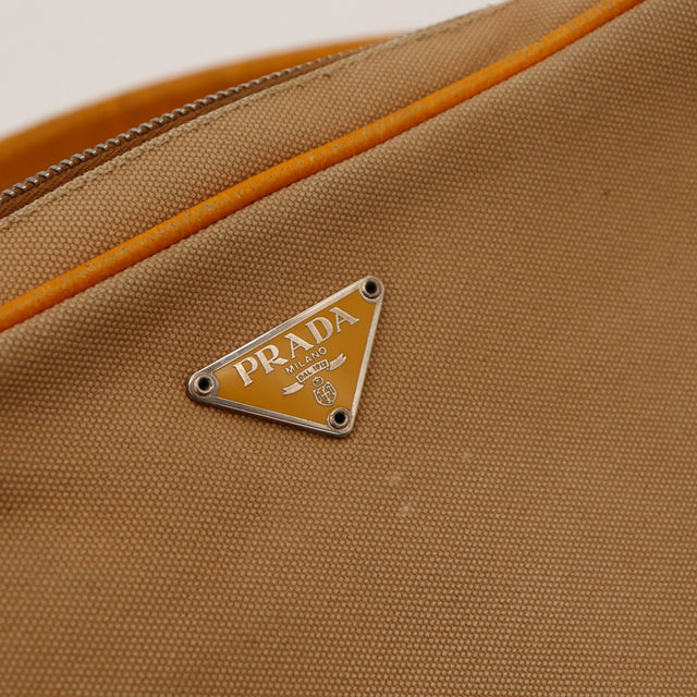 Détail plaque logo Prada Milano sur toile beige — AMANA Vintage
