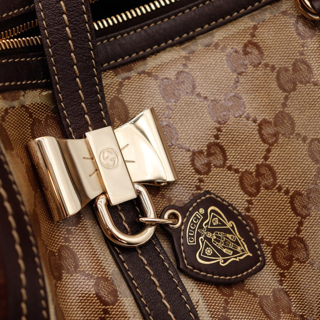 Détail nœud doré et breloque blason Gucci Boston occasion authentique — AMANA Vintage