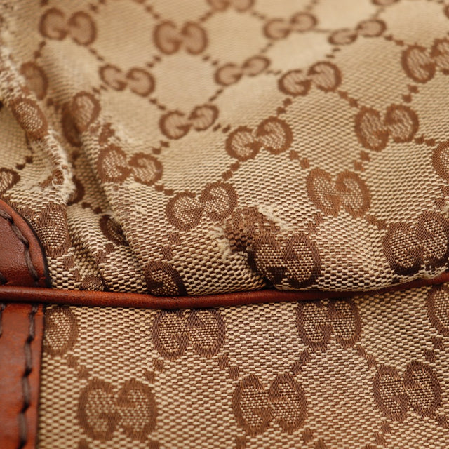 Détail des clous dorés Gucci Hobo Jockey toile monogrammée beige et ébène occasion authentique — AMANA Vintage