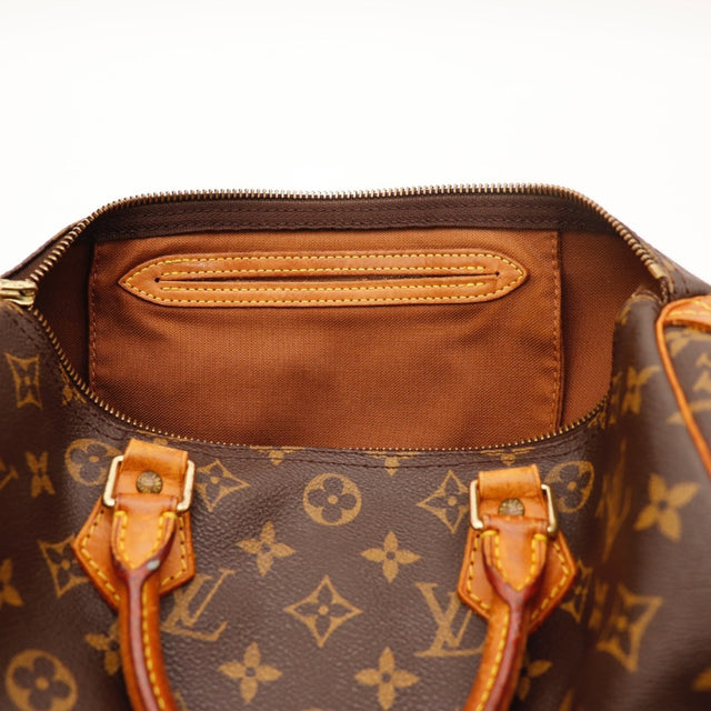Gros plan de la tirette en cuir Louis Vuitton Speedy 30 Toile Monogramme occasion authentique — AMANA Vintage