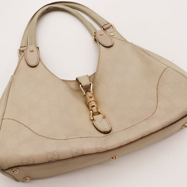 Détail fermoir piston doré Gucci New Jackie cuir Guccissima taupe — AMANA Vintage