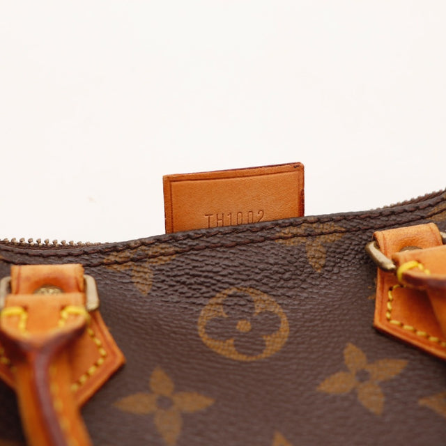 Détail de la languette latérale Louis Vuitton Mini Speedy Toile Monogramme occasion authentique — AMANA Vintage