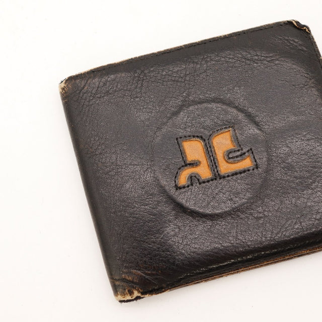 Detail logo Courreges bicolore orange sur portefeuille cuir noir vintage — AMANA Vintage