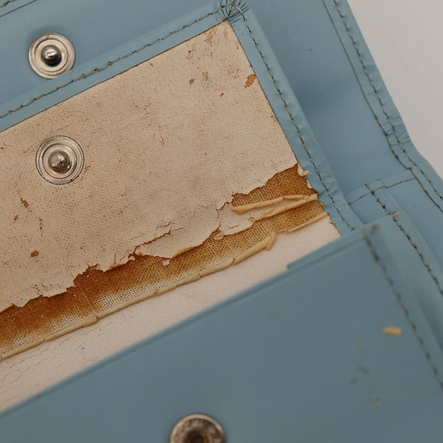 Détail défaut intérieur portefeuille Courrèges revêtement décollé — AMANA Vintage