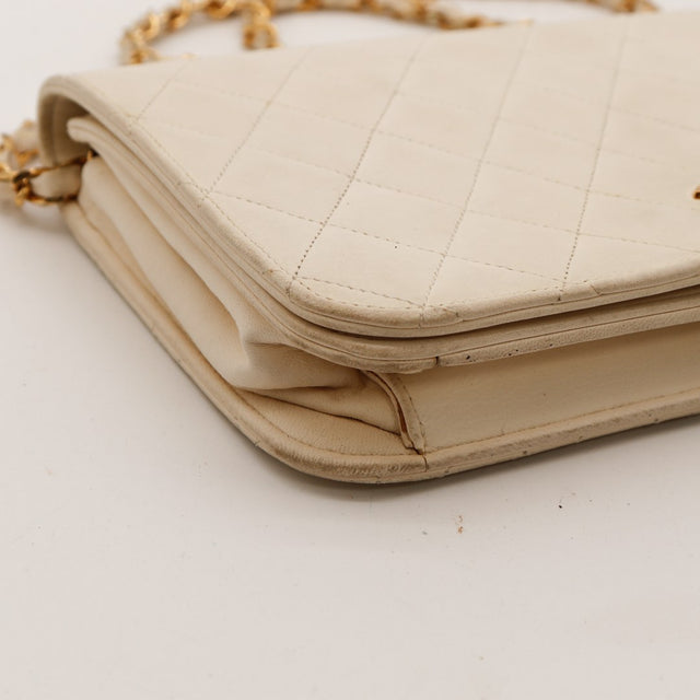 Détail coin supérieur Pochette Chanel matelassée beige ivoire — AMANA Vintage