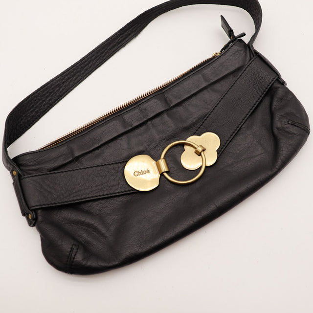 Détail fermoir rond doré Chloé gravé sur cuir noir — AMANA Vintage