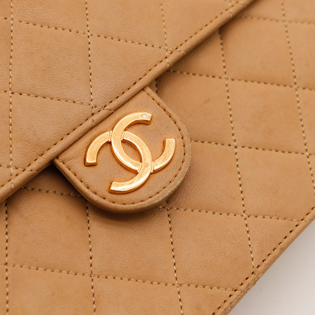 Detail fermoir CC doré cuir matelassé beige Chanel Classic Flap — AMANA Vintage