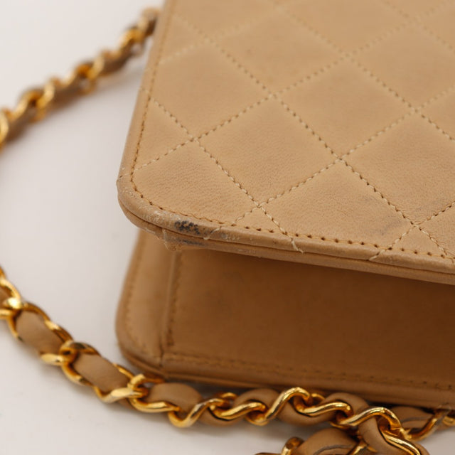 Detail coin supérieur et chaîne Chanel Classic Flap beige vintage — AMANA Vintage