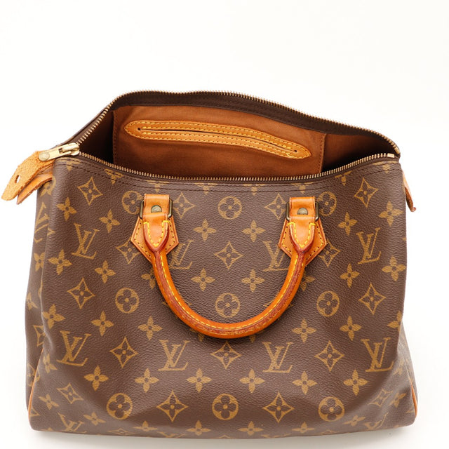 Détail coin gauche Louis Vuitton Speedy 30 languette cadenas patine — AMANA Vintage