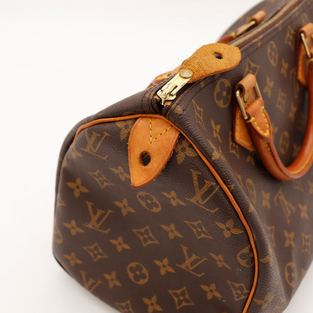 Détail coin inférieur Louis Vuitton Speedy 30 languette cadenas cuir vachette caramel — AMANA Vintage