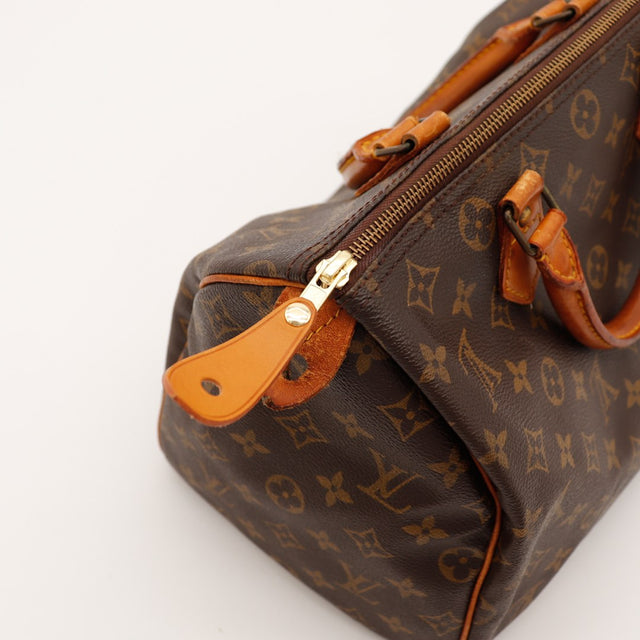 Détail coin Louis Vuitton Speedy 30 languette cadenas vachette — AMANA Vintage