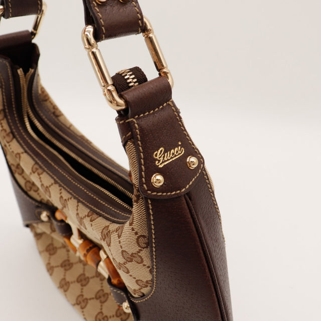 Détail anse et breloque Gucci Hobo Bambou cuir marron logo script — AMANA Vintage