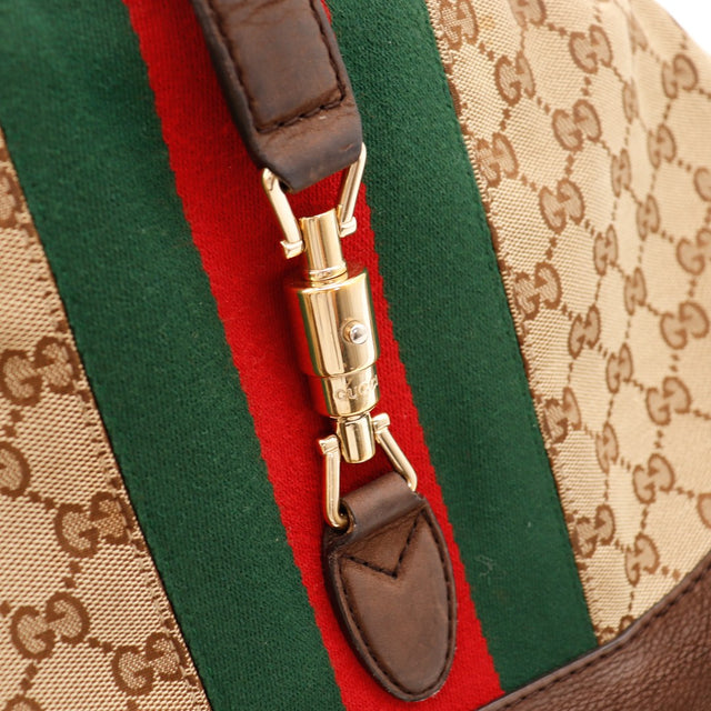 Détail fermoir piston doré bande Web Gucci New Jackie Web gros plan — AMANA Vintage